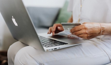 kobieta robiąca zakupy w sklepie internetowym trzymająca kartę płatniczą